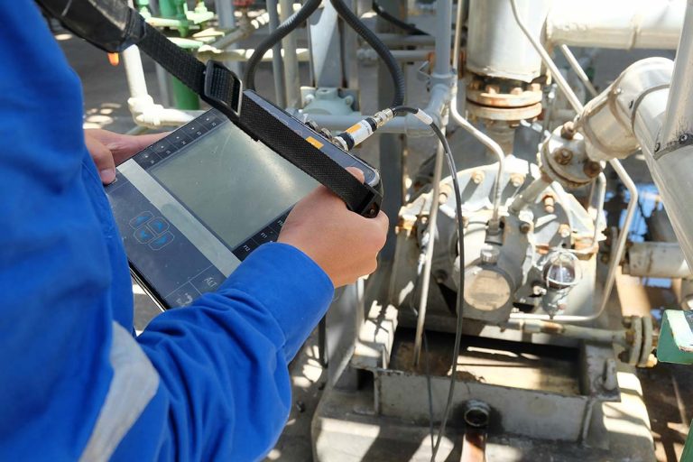 Mechanical engineer using vibration meter on centrifugal pump